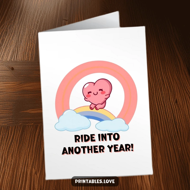 Funny Free Printable Birthday Card showing a rosy-cheeked heart character joyfully sliding down a vibrant rainbow.